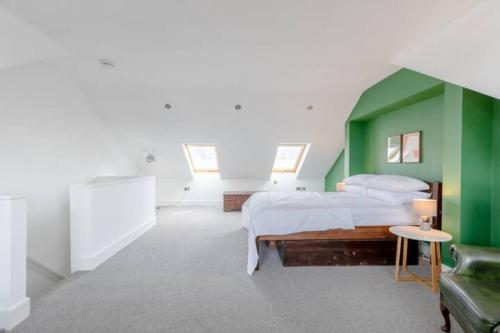 a green and white bedroom with a bed and a couch at Spacious 2 Bedroom Retreat In East Dulwich in London