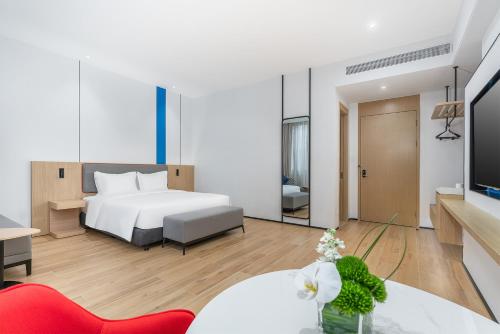 a bedroom with a bed and a living room at Holiday Inn Express Wenchang by IHG in Wenchang