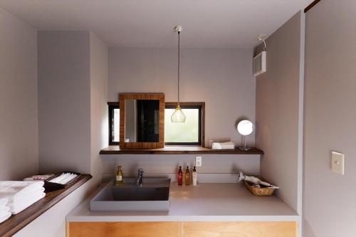 a bathroom with a sink and a mirror at Stay UWU 001 ステイ ウー 001 in Kochi