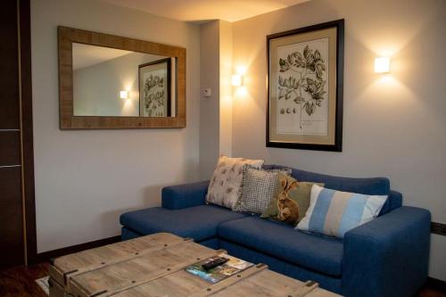 a living room with a blue couch and a table at Bluebell Northbrook Park Chalet in Farnham