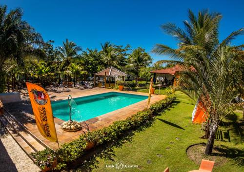 - une piscine dans un complexe avec des palmiers dans l'établissement Pousada Beach Bahia, à Porto Seguro