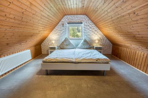 a bed in a room with a wooden ceiling at Ferienhaus Rosswangen in Balingen