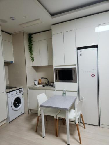 a kitchen with a table and chairs and a refrigerator at The Mark Sokcho Residence Hotel #15F in Sokcho