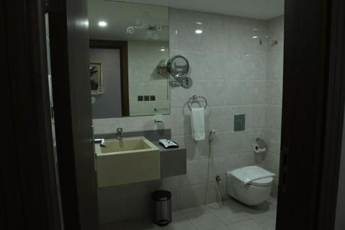 a bathroom with a sink and a toilet and a mirror at YM Resort in Yanbu