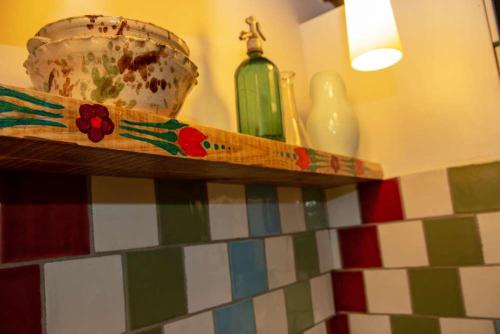 a shelf with a green bottle and a bowl on it at Casa Batrana in Zece Hotare