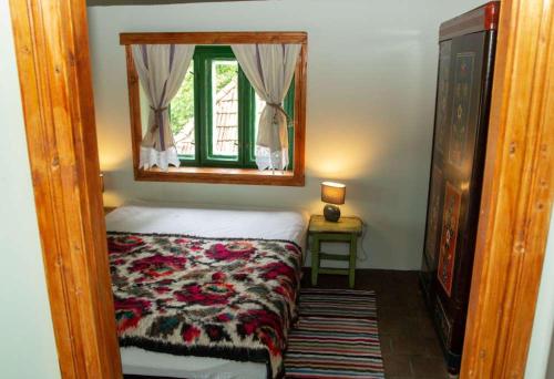 ein kleines Schlafzimmer mit einem Bett und einem Spiegel in der Unterkunft Casa Batrana in Zece Hotare