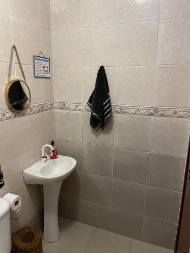 a bathroom with a sink and a towel on the wall at Suíte com cozinha para casal in Araruama