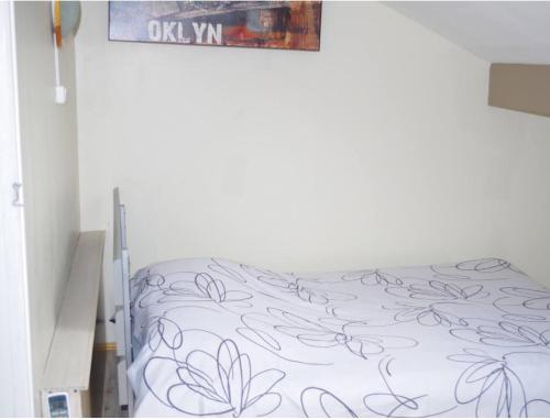 - une chambre avec un lit doté d'un couvre-lit blanc et de fleurs dans l'établissement L'appartement 90m2 climatisé, à Avignon