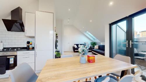 a kitchen and dining room with a table and chairs at Penthouse Style Apartment in London