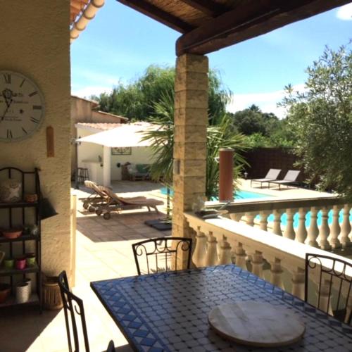 d'une terrasse avec une table et une horloge murale. dans l'établissement Villa La Lavande, à Montaren-et-Saint-Médiers