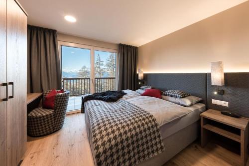 a bedroom with a bed and a large window at Piz Aich Natur Chalet Panorama in Avelengo