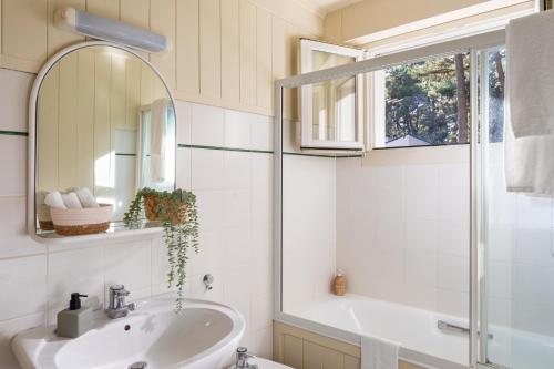 une salle de bain avec un lavabo et un miroir dans l'établissement Villa Maison blanche, Arenal, à La Baule