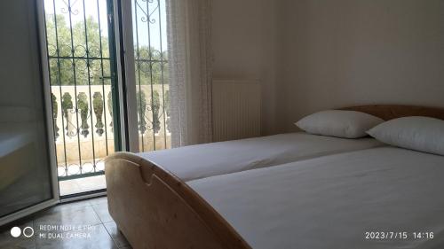 1 dormitorio con cama y ventana grande en The Villa with the Aromatic Herbs, en Agia Triada