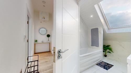 ein Bad mit einer ebenerdigen Dusche und einem Dachfenster in der Unterkunft Penthouse Style Apartment in London
