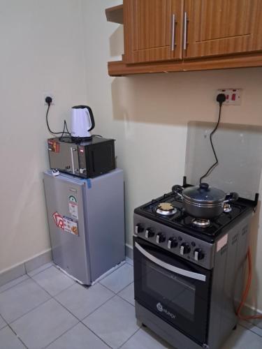 a kitchen with a stove and a refrigerator at Tirisi Homes in Machakos