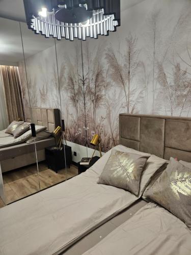 a bedroom with a bed and a chandelier at Apartament Gold in Biała Podlaska
