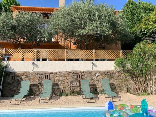 un groupe de chaises assises à côté d'une piscine dans l'établissement Villa avec piscine dans les cévennes, à Bessèges