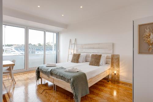 a white bedroom with a large bed and a window at Belém River Apartment View in Lisbon