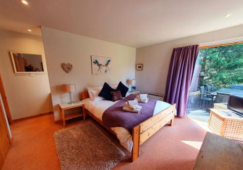 1 dormitorio con cama y ventana grande en Ptarmigan Lodge Nethy Bridge, en Nethy Bridge