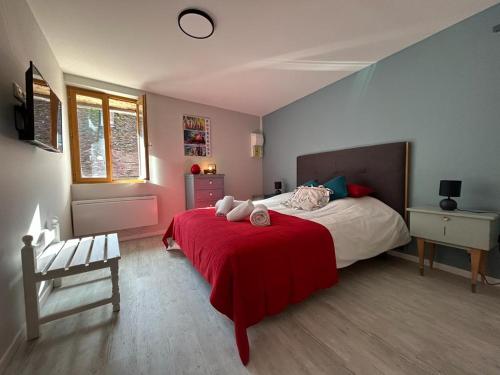 ein Schlafzimmer mit einem großen Bett mit einer roten Decke in der Unterkunft Le Bourguignon in Toucy