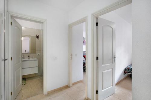 a bathroom with two white doors and a sink at Beach Front Apartment Puertito in Güimar