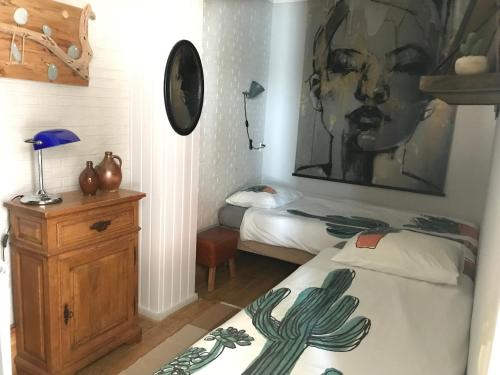 a bedroom with two beds and a painting on the wall at Klein Haasdal Studio's in Schimmert