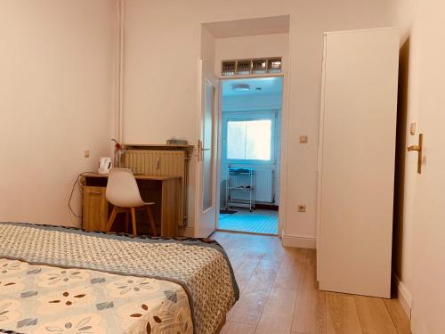 1 dormitorio con cama, escritorio y mesa en Nice private room in Luxembourg City, en Luxemburgo