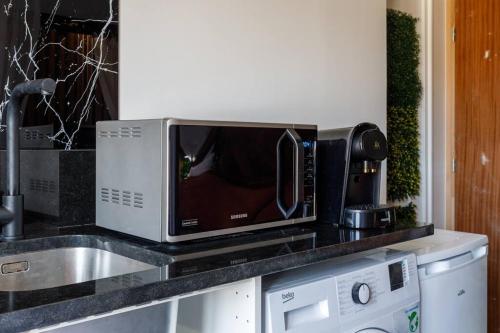 un microondas en la parte superior de una barra de cocina en Proche Paris - Style Bali 350 m gare Mantes, en Mantes-la-Jolie