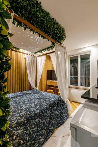 une chambre avec un lit à baldaquin dans l'établissement Proche Paris - Style Bali 350 m gare Mantes, à Mantes-la-Jolie