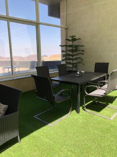 a table and chairs in a room with green carpet at The RN Hotels in Wadi Musa