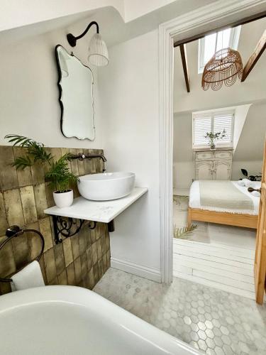 a bathroom with a tub and a sink and a bed at Stunning 3 bedroom & 2 bathroom cottage with patio in Brighton & Hove