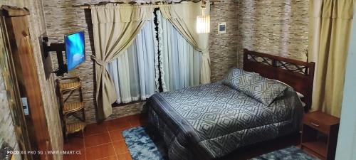 a bedroom with a bed and a television in it at Westside - Habitación con baño privado in Santa Cruz