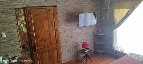 a room with a brick wall with a wooden door at Westside - Habitación con baño privado in Santa Cruz