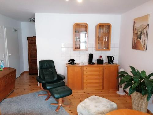 a living room with a chair and a desk at Pension Am Buhnenkopf in Tangermünde