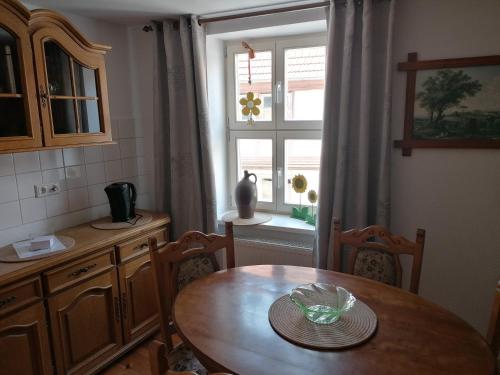 a kitchen with a wooden table and a window at Pension Am Buhnenkopf in Tangermünde