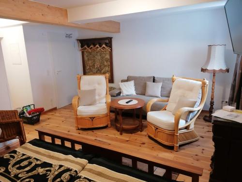 a living room with two chairs and a couch at Pension Am Buhnenkopf in Tangermünde