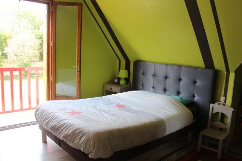 1 dormitorio con 1 cama grande y pared verde en La Trémouchère, en Gesvres