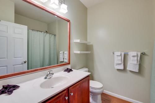 La salle de bains est pourvue d'un lavabo, d'un miroir et de toilettes. dans l'établissement Capitol Heights Apartment about 8 Mi to National Mall!, à Capitol Heights