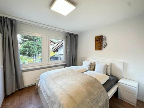 um quarto com uma cama grande e uma janela em Alpine magic for the whole family near Zermatt em Täsch