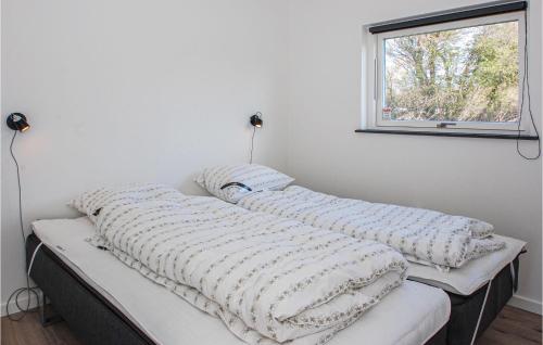 2 Kissen auf einem Bett in einem Zimmer mit Fenster in der Unterkunft Gorgeous Home In Haderslev With Kitchen in Knud