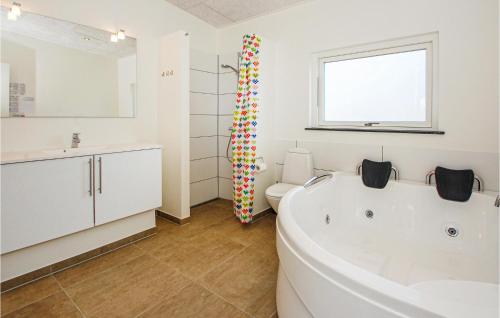 a bathroom with a tub and a toilet and a sink at Awesome Home In Haderslev With 4 Bedrooms, Sauna And Wifi in Knud