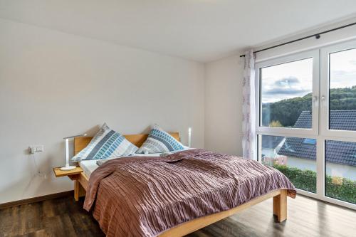 una camera da letto con un letto e una grande finestra di Ferienwohnungen Kapellenblick a Biederbach Baden-Württemberg