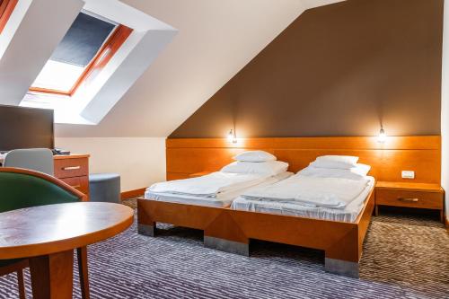 a hotel room with a bed and a table at Hotel Kranjska Gora in Kranjska Gora