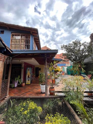 a house with a deck with plants in front of it at Yolo Hostel Medellin in Medellín