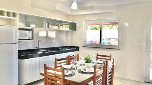 a kitchen with a table and chairs and a refrigerator at Casa Luna in Porto Seguro