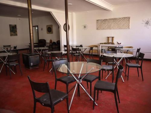 a dining room with tables and chairs and a tv at Hotel Termas del Salitre in Mamiña