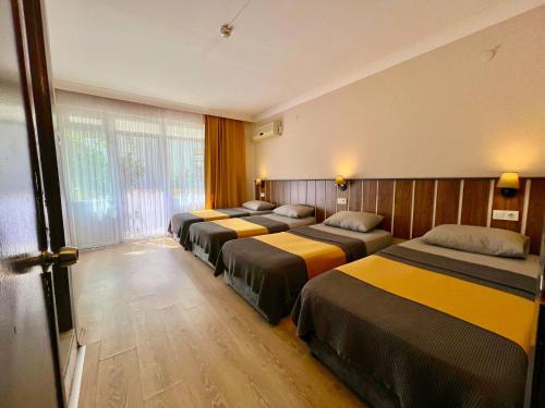 eine Reihe von Betten in einem Hotelzimmer in der Unterkunft Cord Hotel & Resort in Edremit