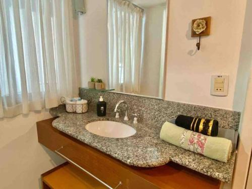 a bathroom counter with a sink and a mirror at Ocean Flat 407 in Vila Velha