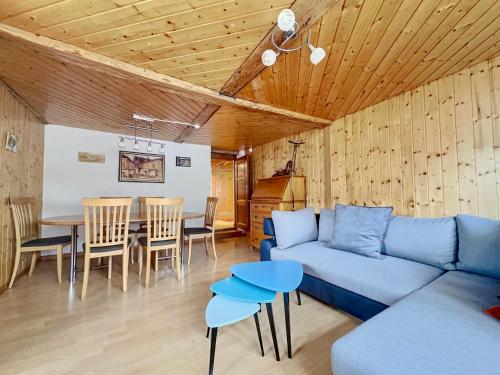 a living room with a blue couch and a table at Les Antilles l Bucolique l 6pers in Vercorin