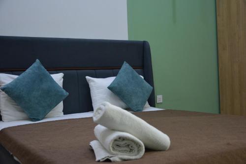 a pile of towels on a bed with pillows at Perron Hotel Baku in Baku